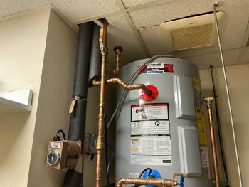 Water heater and copper plumbing pipes installed in a utility closet